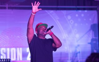 Rapper performing on stage, vibrant lighting