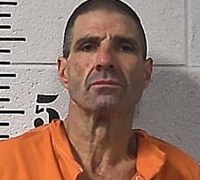 Mugshot of person in orange jumpsuit with measurements